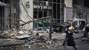 A woman paces past buildings destroyed by recent Russian attacks in Kyiv, Ukraine, Friday, Dec. 20, 2024. AP