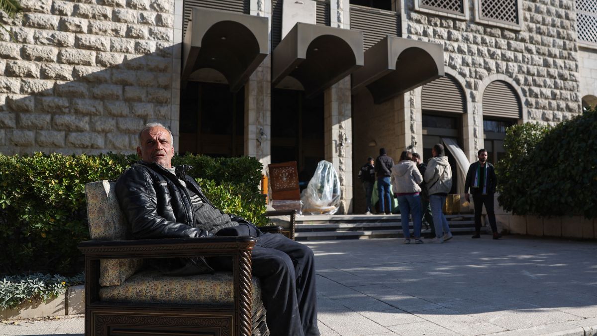 A man sits in an armchair outside the residential palace of Syria's ousted president Bashar al-Assad in Damascus. AFP
A man sits in an armchair outside the residential palace of Syria's ousted president Bashar al-Assad in Damascus. AFP