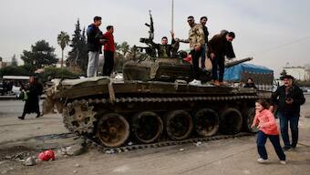 People stand on a tank while celebrating the ouster of Bashar al-Assad, in Sednaya, Syria, December 11, 2024. Reuters
