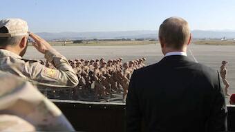 Russian President Vladimir Putin (R) and Defence Minister Sergei Shoigu watch servicemen passing by as they visit the Hmeymim air base in Latakia Province, Syria December 11, 2017. Reuters