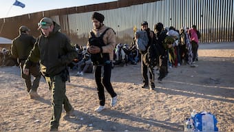 A U.S. Border Patrol agent leads a group of Indian immigrants from the U.S.-Mexico border on December 08, 2023 in Lukeville, Arizona. File image/ AFP