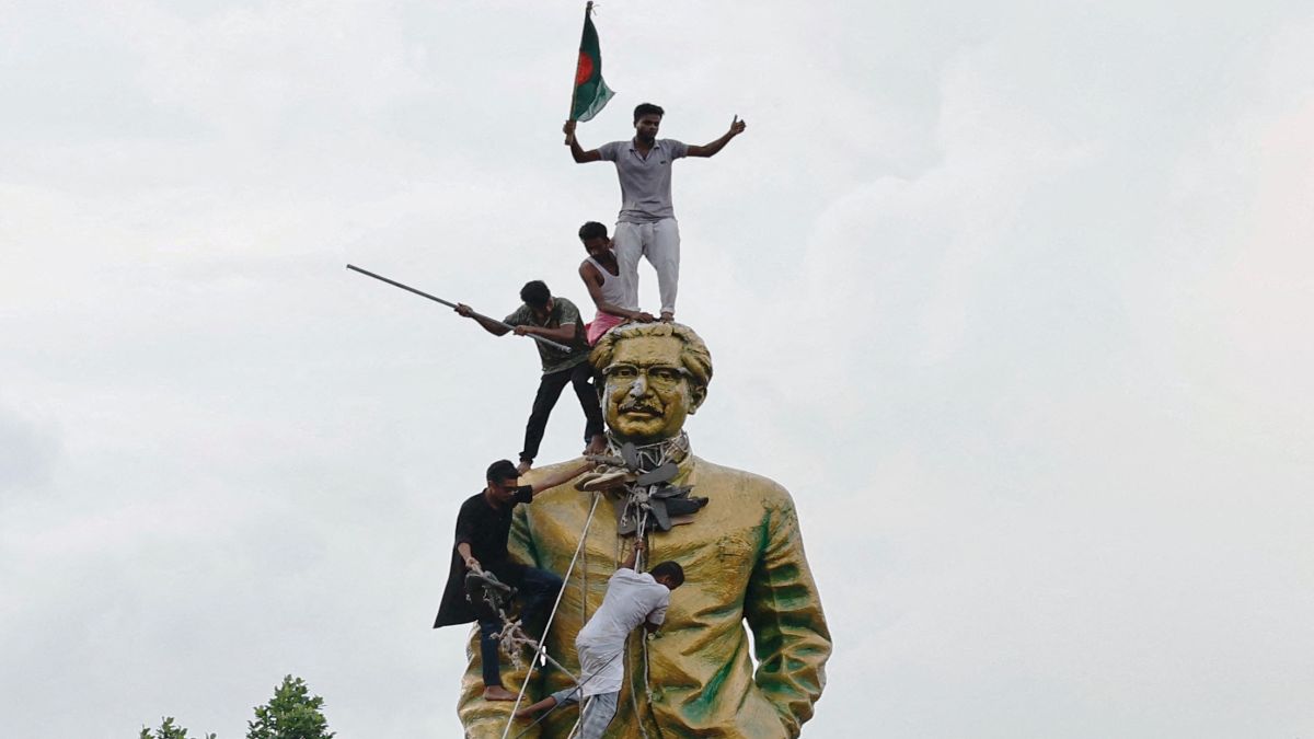 People climb the statue of Sheikh Mujibur Rahman at the Bijoy Sarani area, as they celebrate the resignation of the Prime Minister Sheikh Hasina in Dhaka, Bangladesh on August 5. File image/AFP People climb the statue of Sheikh Mujibur Rahman at the Bijoy Sarani area, as they celebrate the resignation of the Prime Minister Sheikh Hasina in Dhaka, Bangladesh on August 5. File image/AFP