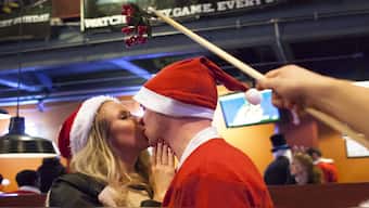 A couple share an impromptu kiss under  mistletoe in Seattle, Washington. For centuries, mistletoe has become a cherished part of Christmas traditions. Representational image/Reuters