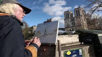 An artist paints a view of Notre-Dame de Paris cathedral, in front of the cathedral a few days before its reopening, in Paris.  The Notre-Dame Cathedral is set to re-open with ceremonies on December 7 and 8, 2024, five years after the 2019 fire which ravaged the world heritage landmark and toppled its spire. AFP