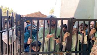 A man stands with his passport and identity cards of his family members, at a closed pedestrian crossing gate at the crossing border, in Torkham, Pakistan. Image used for representative purpose/Reuters
