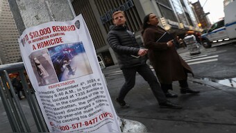 People walk past a poster outside the Hilton hotel near the scene where the CEO of UnitedHealthcare Brian Thompson was shot dead in Midtown Manhattan, in New York. Reuters