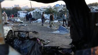 Palestinians walk amid scattered debris of tents on Thursday following an overnight Israeli strike on a makeshift displacement camp in al-Mawasi in the southern Gaza Strip. File image/AFP