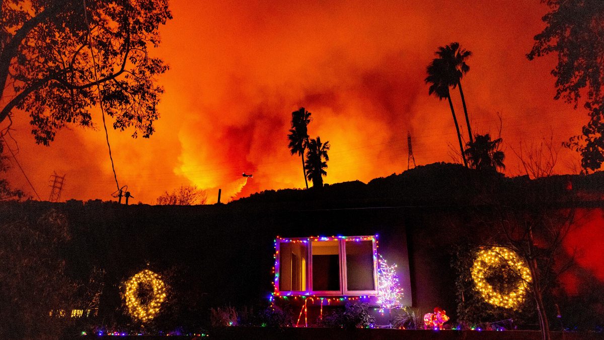 A helicopter drops water on the Palisades Fire behind a home with Christmas lights in Mandeville Canyon. AP A helicopter drops water on the Palisades Fire behind a home with Christmas lights in Mandeville Canyon. AP