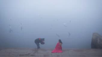 A girl gets her picture clicked on the banks of the Yamuna river on a foggy winter morning in New Delhi, January 3, 2025. Source: Reuters. 