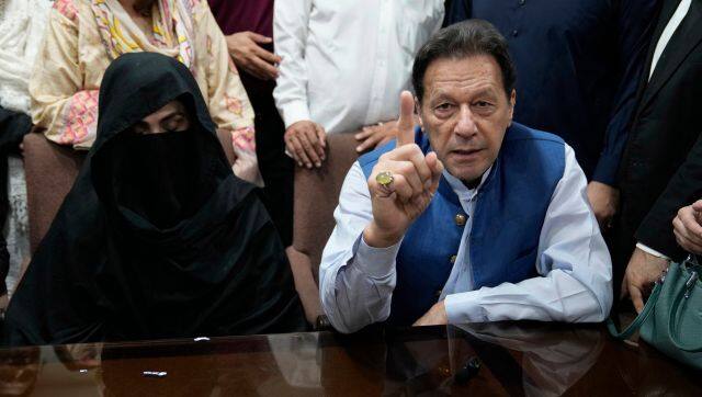 Pakistan's former Prime Minister Imran Khan, right, and his wife Bushra Bibi speak to the media before signing documents to submit surety bond over his bails in different cases. AP/file image