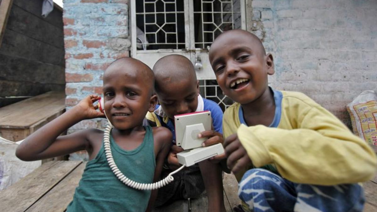 Boys play with a toy telephone as they react to the camera at a slum in New Delhi. Source: Reuters | File. Boys play with a toy telephone as they react to the camera at a slum in New Delhi. Source: Reuters | File.