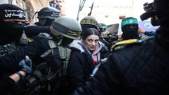 Palestinian militant group Islamic Jihad and Hamas fighters escort Israeli hostage Arbel Yehud to hand her over to a Red Cross team in Khan Yunis on Thursday, as part of their third hostage-prisoner exchange. AFP
