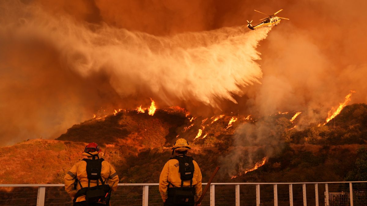 Firefighters watch as water is dropped on the Palisades Fire in Mandeville Canyon Saturday, Jan. 11, 2025, in Los Angeles. Image- AP Firefighters watch as water is dropped on the Palisades Fire in Mandeville Canyon Saturday, Jan. 11, 2025, in Los Angeles. Image- AP