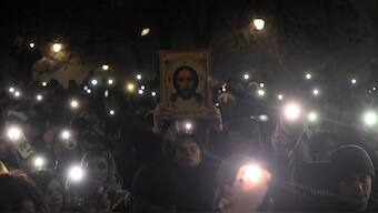 A protestor holds an orthodox icon as a thousands of students attend a protest on New Year's Eve to demand accountability for the November train station roof collapse that killed 15 people in Belgrade, Serbia. AFP