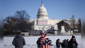 People stand as the U.S. Capitol is seen behind the frozen Capitol reflecting pool. Reuters