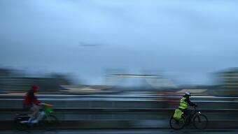 Cyclists cross London Bridge, early in the morning of January 24, 2025, as the capital avoids the worst of Storm Eowyn, which is bringing winds of 100 mph to other parts of the UK and Ireland. AFP