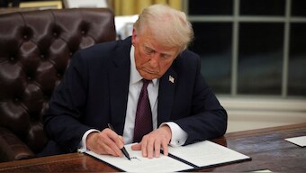 Donald Trump signs documents as he issues executive orders and pardons for January 6 defendants in the Oval Office at the White House. Reuters
