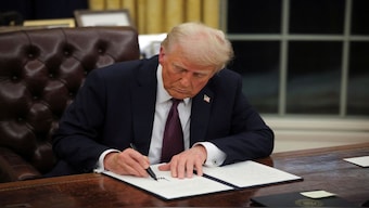 US President Donald Trump signs documents as he issues executive orders. Reuters File