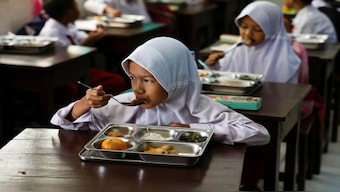 Students eat meals from the free nutritious meals programme at a school in Jakarta, Indonesia. Reuters