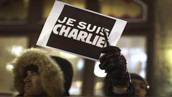 A man holds a pen with a sign during a vigil, for the victims of a shooting by gunmen at the offices of weekly satirical magazine Charlie Hebdo in Paris, at the French consulate in Quebec City. The sign reads, "I am Charlie". File image/Reuters