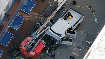 A black flag with white lettering lies on the ground rolled up behind a pickup truck that a man drove into a crowd on Bourbon Street in New Orleans, killing and injuring a number of people, early Wednesday morning. AP