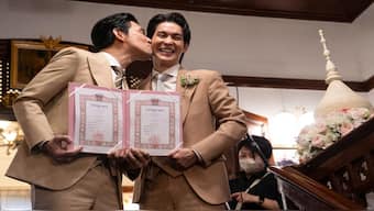 Thai actors Apiwat "Porsch" Apiwatsayree (left) and Sappanyoo "Arm" Panatkool pose for pictures after registering their same-sex marriage at the Phra Nakhon district office in Bangkok. AFP