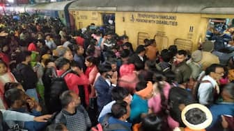 Passengers jostle with each other to board a train at the New Delhi railway station on 15 February. AP