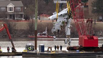 Rescue and salvage crews with cranes pull up the wreckage of an American Airlines jet in the Potomac River from Ronald Reagan Washington National Airport, in Arlington, Va. AP