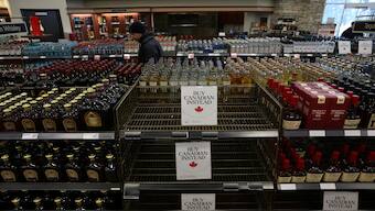 A customer looks at the bottles on display as empty shelves remain with signs ''Buy Canadian Instead'' after the top five US liquor brands were removed from sale at a B.C. Liquor Store, as part of a response to US President Donald Trump's 25% tariffs on Canadian goods, in Vancouver, British Columbia, Canada, February 2, 2025. Reuters 
