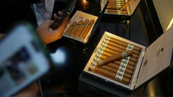 Visitors photograph cigars on display during the XXV Cigar Festival at Convention Palace in Havana, Cuba, Tuesday, February 24, 2025. File Image/AP