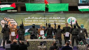 Israeli captives, from left to the right, Ohad Ben Ami, Eli Sharabi and Or Levy, who have been held hostage by Hamas in Gaza since October 7, 2023, are escorted by Hamas fighters before being handed over to the Red Cross in Deir al-Balah, central Gaza Strip, on Saturday. AP File