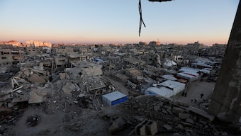 Palestinians walk near the rubble of buildings, amid a ceasefire between Israel and Hamas, in Khan Younis, in the southern Gaza Strip, on February 27, 2025. Reuters
