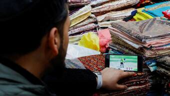 A shopkeeper in Srinagar, Jammu and Kashmir, watches the Champions Trophy Group A match between India and Pakistan in Dubai. Reuters