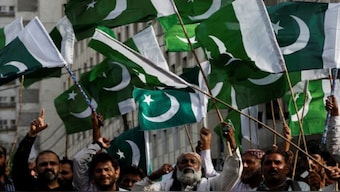 People wave flags as they chant slogans during a rally in Karachi. File Image / Reuters