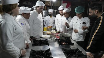 Chef Ali Haider, right, teaches transgender persons during their cooking class at the Culinary & Hotel Institute of Pakistan, in Lahore, Pakistan. AP