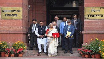 Finance Minister Nirmala Sitharaman, carrying a red pouch containing budget documents, poses for a photograph with colleagues as she arrives to present the budget in the Parliament in New Delhi, on Saturday. AP