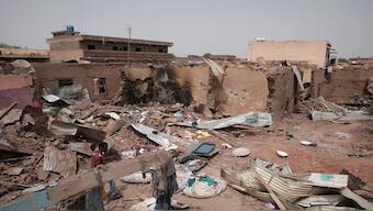 A man walks by a house hit in recent fighting in Khartoum, Sudan, an area torn by fighting between the military and the notorious paramilitary Rapid Support Forces, on April 25, 2023. AP File