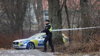An officer unrolls police tape as a major police operation is underway at Risbergska School, following reports of a serious violent crime, in Orebro, Sweden. Reuters