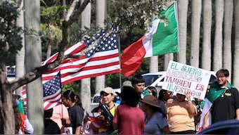 Demonstrators protest against the immigration policies imposed by U.S. President Donald Trump, as Trump's motorcade departs his golf club in West Palm Beach, Florida, U.S. Reuters