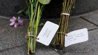 Flowers lie at the base of a flagpole, as the USAID building sits closed. Reuters
