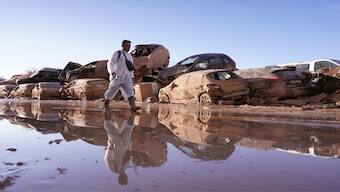 A man walks past stacked up cars after floods in Catarroja that left hundreds dead or missing in the Valencia region in Spain, on November 12, 2024. AP File