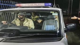 Police personnel take deported immigrants for initial questioning after a US military aircraft carrying them landed at the Shri Guru Ramdas Ji International Airport, in Amritsar on Wednesday. PTI