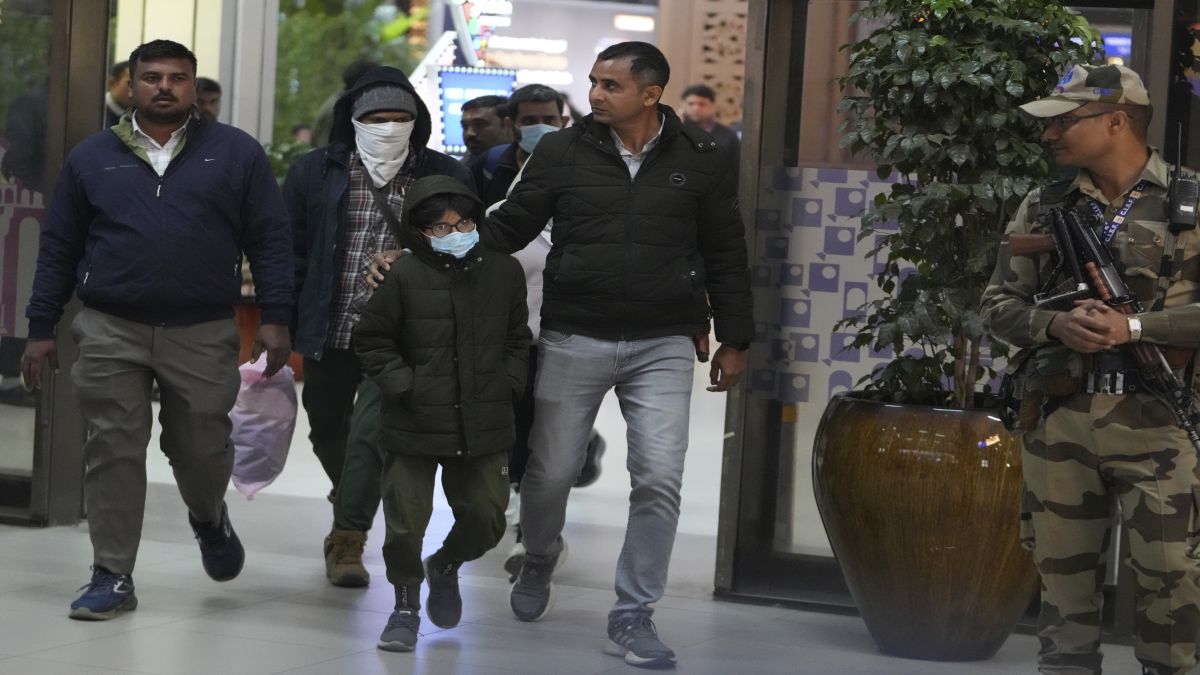 Indian police officials escort immigrants, wearing masks, deported from the United States, who were among those who arrived in a US military plane in Amritsar. AP Indian police officials escort immigrants, wearing masks, deported from the United States, who were among those who arrived in a US military plane in Amritsar. AP