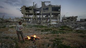 A man stands by a fire next to a destroyed house in an area littered with rubble from buildings demolished during the Israeli army's ground and air offensive against Hamas in Gaza City. US President Donald Trump, on Tuesday, announced that there was a plan for the US to "take over Gaza" and transform it into the "Riviera of the Middle East". AP