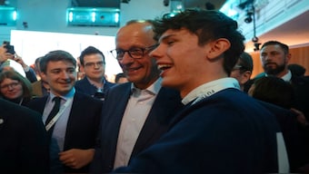 German conservative candidate for chancellor and Christian Democratic Union (CDU) party leader Friedrich Merz poses for a selfie with a supporter after his bloc was declared winner in the elections. Reuters