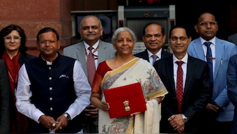 India's Finance Minister Nirmala Sitharaman poses with officials while leaving her office to present the Union Budget. She has chosen a white saree with Madhubani painting for the occasion. Reuters