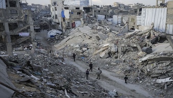 (File) Palestinians walk in the destruction caused by the Israeli air and ground offensive in Jabaliya, Gaza Strip. Gazans have opposed Trump's proposal, saying that Gaza is their homeland. AP