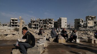 People sit after receiving bread from Ecir Kapici, Turkish humanitarian NGO at al-Yarmouk Palestinian refugee camp, after Syria's Bashar al-Assad was ousted, in Damascus, Syria. File image/ Reuters