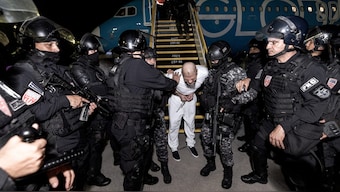 Salvadoran police officers escort alleged members of the Venezuelan gang Tren de Aragua recently deported by the U.S. government to be imprisoned in the Terrorism Confinement Center (CECOT) prison, as part of an agreement with the Salvadoran government, at the El Salvador International Airport in San Luis Talpa, El Salvador, in this handout image obtained March 16, 2025. Reuters