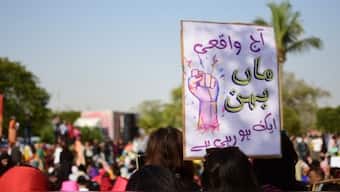 Aurat March protesters hold signs in Pakistan. X